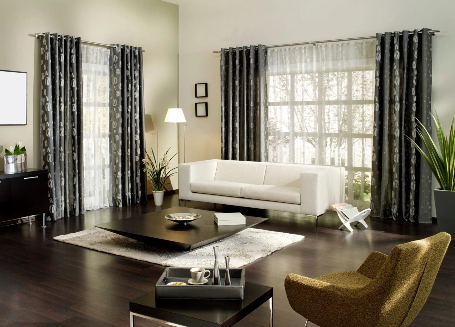 A living room with dark wood floors and white furniture.